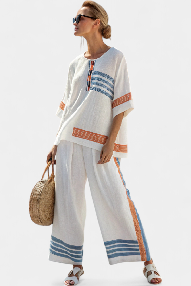 Conjunto étnico Daisy en blanco con detalles azules y naranjas: un estilo único y vibrante.