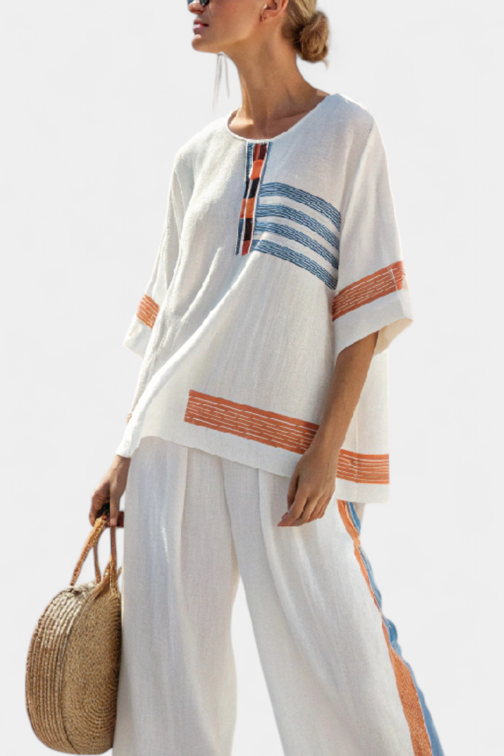 Conjunto étnico Daisy en blanco con detalles azules y naranjas: un estilo único y vibrante.