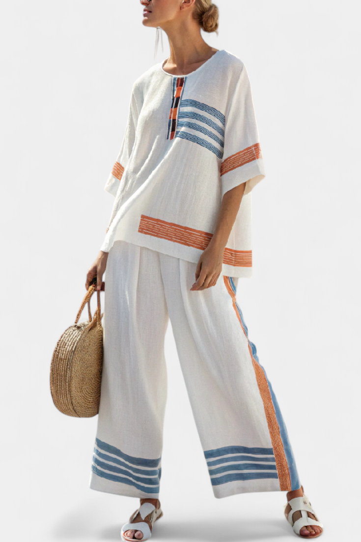 Conjunto étnico Daisy en blanco con detalles azules y naranjas: un estilo único y vibrante.